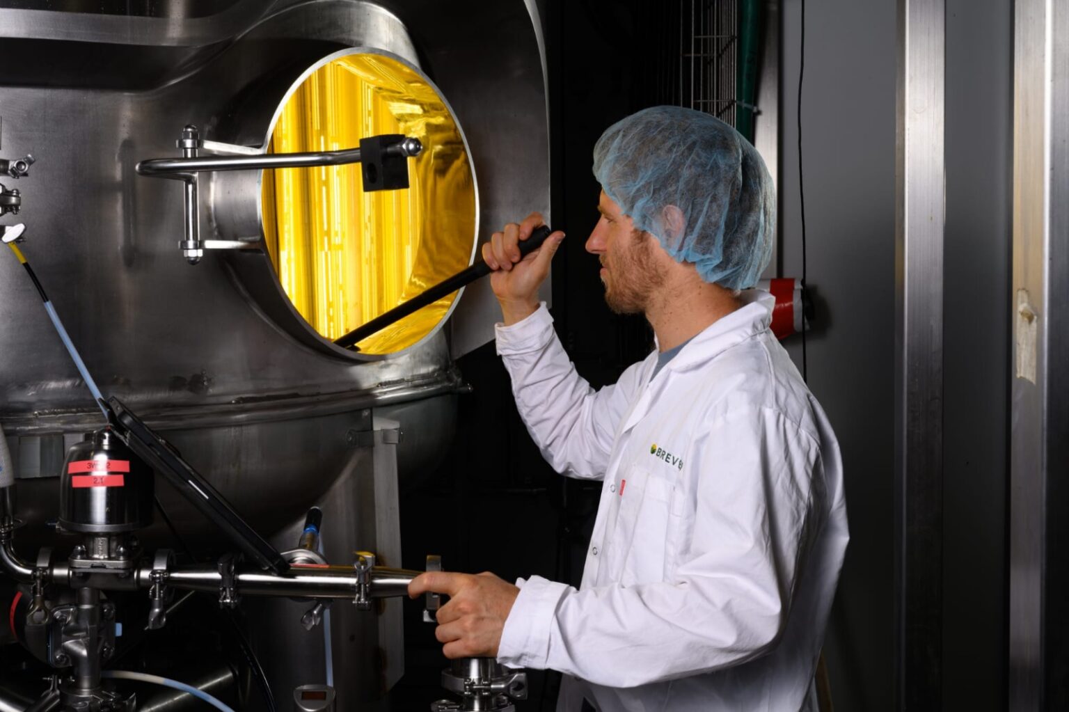 Brevel scientist operating fermentation equipment.